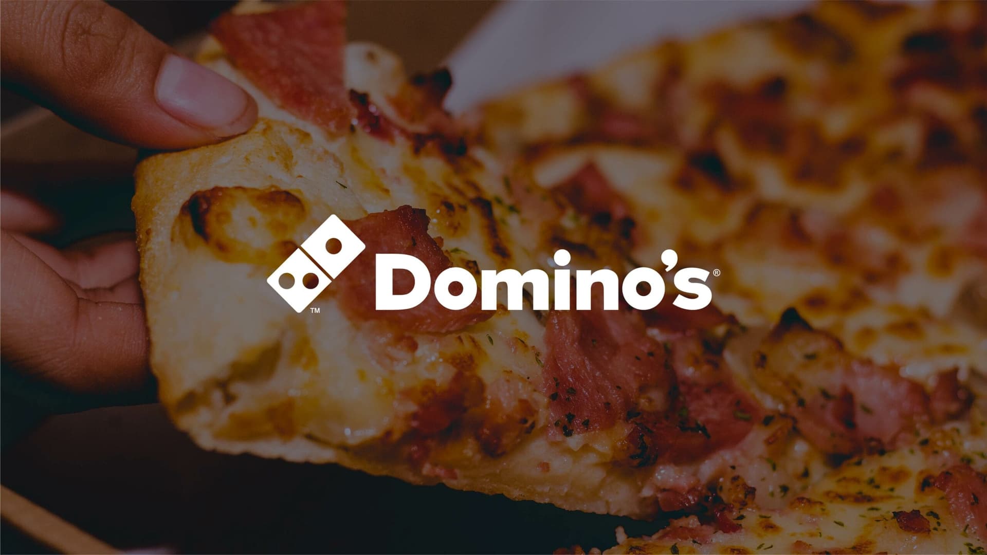 Dominos logo in white with a pizza background